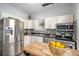 Bright kitchen with stainless steel appliances, white cabinets, and a backsplash of mosaic tiles at 2841 N Franklin St, Denver, CO 80205