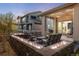 Backyard featuring an outdoor seating area with a lit stone fire pit and furniture at dusk at 16392 Spanish Peak Way, Broomfield, CO 80023
