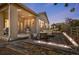 Backyard featuring an outdoor seating area with a lit stone fire pit and furniture at dusk at 16392 Spanish Peak Way, Broomfield, CO 80023