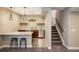 Finished basement bar area with a bar top, stools, cabinets, sink, and stairs to the upper level at 16392 Spanish Peak Way, Broomfield, CO 80023