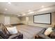 Finished basement with movie screen, two leather couches, and neutral paint at 16392 Spanish Peak Way, Broomfield, CO 80023