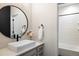 Modern bathroom featuring a vessel sink, round mirror, white subway tile shower, and matte black hardware at 16392 Spanish Peak Way, Broomfield, CO 80023