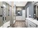 Modern bathroom with glass-enclosed shower, gray walls, tile flooring, and dual vanities at 16392 Spanish Peak Way, Broomfield, CO 80023