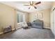 Cozy bedroom featuring a crib, chair, ceiling fan, and window with curtains and natural light at 16392 Spanish Peak Way, Broomfield, CO 80023