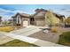Beautiful home featuring a two-car garage, stone accents, and mature landscaping at 16392 Spanish Peak Way, Broomfield, CO 80023