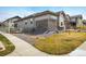 An exterior elevation showing a well manicured lawn with stone and siding accents at 16392 Spanish Peak Way, Broomfield, CO 80023