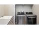 This laundry room includes stainless steel washer and dryer, and a sink with stone countertops at 16392 Spanish Peak Way, Broomfield, CO 80023