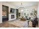 Bright living room featuring a stone fireplace, hardwood floors, large windows, and modern chandelier at 16392 Spanish Peak Way, Broomfield, CO 80023