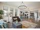 Open concept living room with hardwood floors, a modern chandelier, and access to kitchen at 16392 Spanish Peak Way, Broomfield, CO 80023