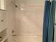 Bright bathroom showcasing bathtub and shower with tile surround and a blue shower curtain at 5455 S Dover S St # 102, Littleton, CO 80123