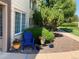 Inviting exterior with a blue Adirondack chair, lush bushes, and colorful potted flowers at 5455 S Dover S St # 102, Littleton, CO 80123
