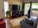 Cozy living room featuring a TV, rug, and sliding glass doors to an outdoor balcony at 5455 S Dover S St # 102, Littleton, CO 80123