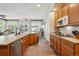 Gourmet kitchen with stainless appliances, wood cabinets, and a view into living and dining areas at 1488 Baguette Dr, Castle Rock, CO 80108