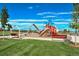 Community playground offers a swing set, slide, and climbing structures on a well-maintained green lawn at 1488 Baguette Dr, Castle Rock, CO 80108