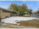 Cozy home featuring a brick facade and a mature tree in the front yard at 300 S Simms St, Lakewood, CO 80228