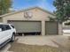 Spacious two-car garage featuring one open bay, a basketball hoop, and side yard access at 300 S Simms St, Lakewood, CO 80228