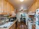 Galley kitchen featuring warm wood cabinets, double sink, and bright natural light at 300 S Simms St, Lakewood, CO 80228