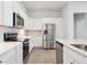 Clean kitchen features white cabinets, stainless appliances and grey backsplash at 485 Interlocken Blvd # 102, Broomfield, CO 80021
