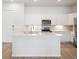 Bright kitchen features white cabinets, stainless appliances, and a large island at 485 Interlocken Blvd # 102, Broomfield, CO 80021