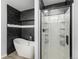 Modern bathroom featuring a soaking tub with black marble tile and a separate glass-enclosed shower at 1963 Hogan Ct, Castle Rock, CO 80109