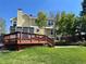 View of the back of the house, including a deck, brick patio and landscaped yard at 9535 W 104Th Ct, Broomfield, CO 80021
