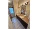 Bright bathroom featuring dual sinks set in a large vanity, complemented by tiled flooring and ample lighting at 9535 W 104Th Ct, Broomfield, CO 80021
