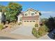 Charming two-story home featuring a stone facade, tan siding, a 2-car garage, and a well-manicured front yard at 9535 W 104Th Ct, Broomfield, CO 80021
