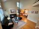 Spacious living room with hardwood floors, tall ceilings, and black leather sofas next to the dining area at 9535 W 104Th Ct, Broomfield, CO 80021