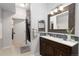 Bathroom featuring a large vanity, modern mirror, tiled shower and a gray accent wall at 3225 Blake St # 6, Denver, CO 80205