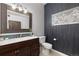 Bathroom with a modern vanity, large mirror, white mosaic flooring, and gray accent wall at 3225 Blake St # 6, Denver, CO 80205