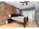Bedroom with exposed brick wall, ceiling fan, and modern finishes at 3225 Blake St # 6, Denver, CO 80205