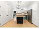 Bright kitchen with an island, pendant lighting, stainless steel appliances, and light wood floors at 3225 Blake St # 6, Denver, CO 80205