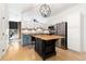 Eat-in kitchen with stainless steel appliances, a kitchen island, and white cabinetry at 3225 Blake St # 6, Denver, CO 80205