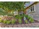 Beautifully landscaped front yard with retaining walls, stone accents, mature trees, and lush plantings at 5506 Irish Pat Murphy Dr, Parker, CO 80134