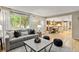 Bright and airy living room featuring a comfortable sofa, stylish decor, and seamless flow into the dining and kitchen areas at 5506 Irish Pat Murphy Dr, Parker, CO 80134