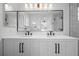 Modern bathroom featuring double sinks, a large mirror, and stylish fixtures at 1464 Spotted Owl Way, Highlands Ranch, CO 80129