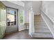 Welcoming entryway featuring hardwood floors, staircase, and a view of the front yard through the glass door at 1464 Spotted Owl Way, Highlands Ranch, CO 80129