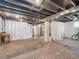 Finished basement with concrete floor and ceiling, decorated with curtains and furniture at 6940 W 48Th Ave, Wheat Ridge, CO 80033