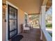 Inviting front porch with cozy seating, decorative columns, and a secure wrought iron door at 6940 W 48Th Ave, Wheat Ridge, CO 80033