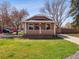 Charming home with a well-manicured lawn and cozy front porch showcasing an American flag at 6940 W 48Th Ave, Wheat Ridge, CO 80033