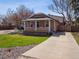 Charming house with a cozy front porch, well-manicured lawn, and a convenient driveway at 6940 W 48Th Ave, Wheat Ridge, CO 80033