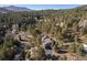 Aerial view of a house on a secluded lot surrounded by lush greenery and tall trees at 29089 Western Ln, Evergreen, CO 80439