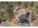 Aerial view of the house, nestled amongst trees on a private lot with a winding driveway at 29089 Western Ln, Evergreen, CO 80439