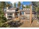 Exterior elevation of a two-story home surrounded by lush greenery and featuring large windows at 29089 Western Ln, Evergreen, CO 80439