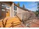 Charming entrance featuring a wooden door, brick walkway, and well-manicured landscaping at 29089 Western Ln, Evergreen, CO 80439