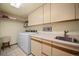 Functional laundry room with washer, dryer, utility sink, and ample cabinet space at 29089 Western Ln, Evergreen, CO 80439