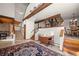 Cozy living room with exposed wood beams, fireplace, and a decorative rug at 29089 Western Ln, Evergreen, CO 80439