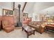 Charming living room with brick fireplace, comfortable seating, and abundant natural light at 29089 Western Ln, Evergreen, CO 80439