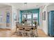 Bright dining room with natural light, a wooden table, modern lighting, and a teal accent wall at 5372 Lenox Ct, Castle Rock, CO 80104
