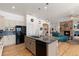 Open kitchen with an island, stainless steel appliances, granite countertops and hardwood floors at 5372 Lenox Ct, Castle Rock, CO 80104